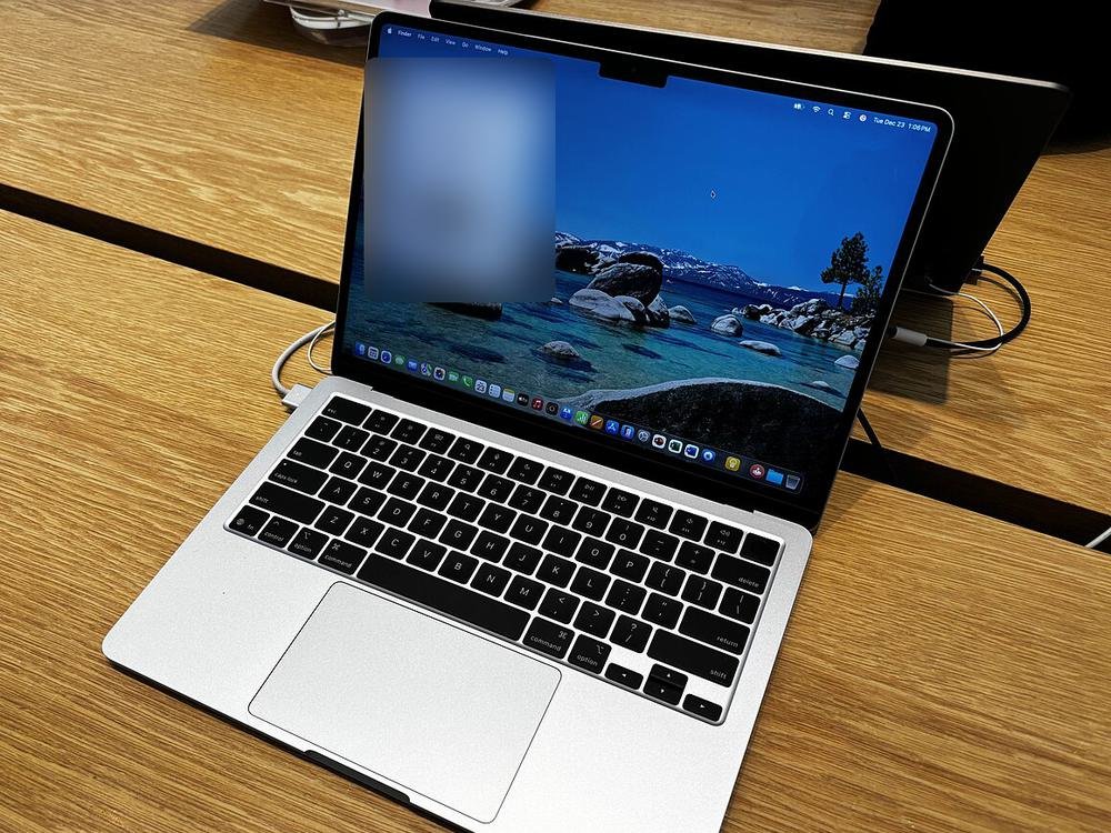 A silver 13-inch MacBook Air open on a wooden table